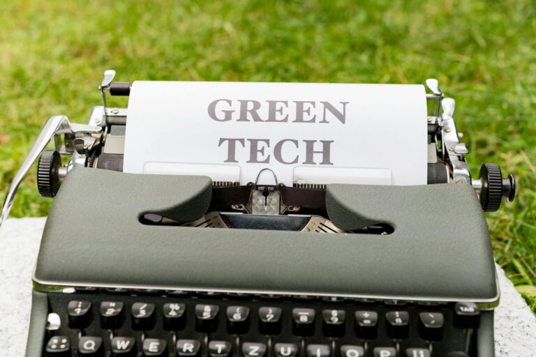 A vintage typewriter typing 'Green Tech' on paper outdoors, symbolizing sustainability.